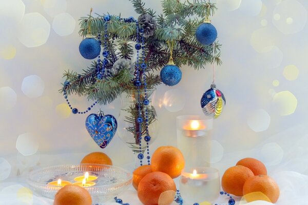 Ramo di un albero di Natale decorato con giocattoli in un cerchio di mandarino