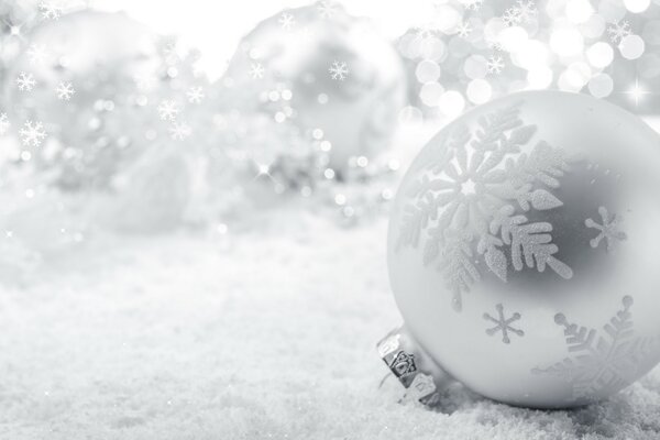 Festive, silver toy on the background of snowflakes