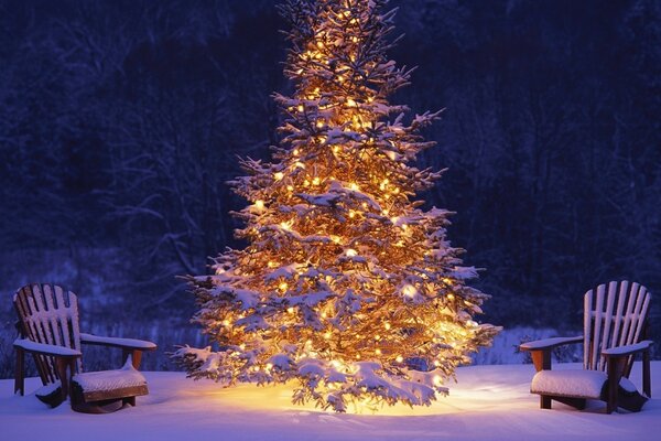 Árbol de Navidad y sillones en la nieve