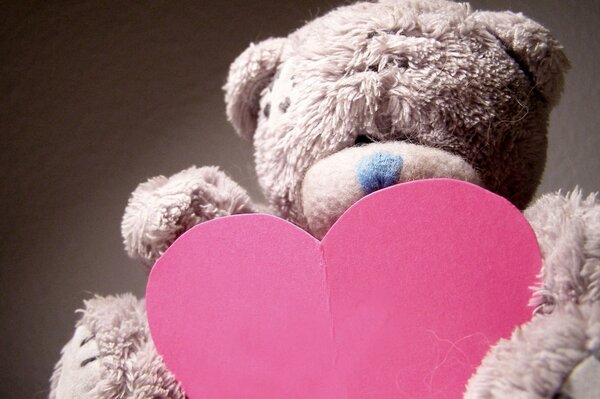 Teddy bear holding a red heart