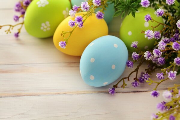 Huevos de Pascua de colores y flores púrpuras