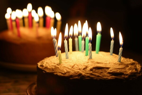 Two cakes with burning candles