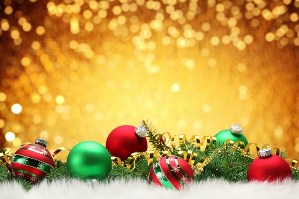 Christmas tree branches with Christmas toys on a golden background