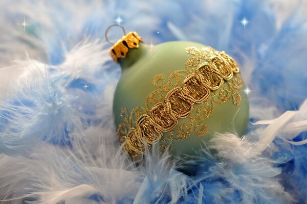 Boule de Noël avec des motifs dorés sur des plumes blanches et bleues