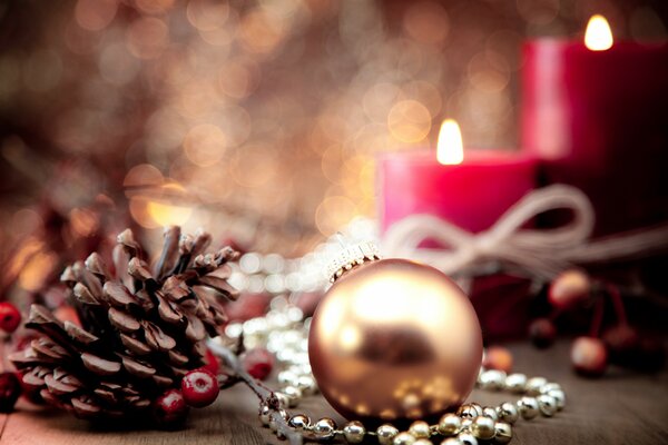 Weihnachtliche Atmosphäre. Eine Kugel, eine Beule und rote Kerzen