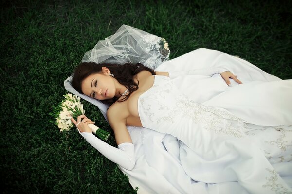 The bride is exhausted on the grass - she finally waited