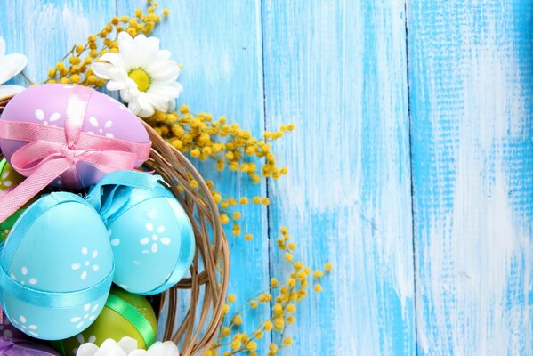 Easter photo of a basket with eggs and daisies