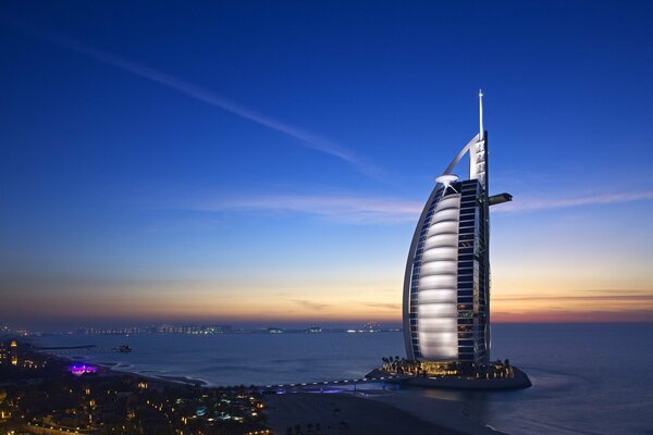 Der luxuriöse Wolkenkratzer Burj al Arab, der in der Nacht über dem Meer thront