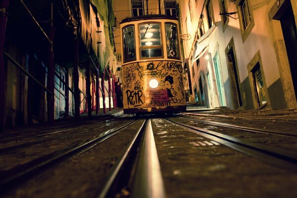 Tram notturno su binari su una strada stretta