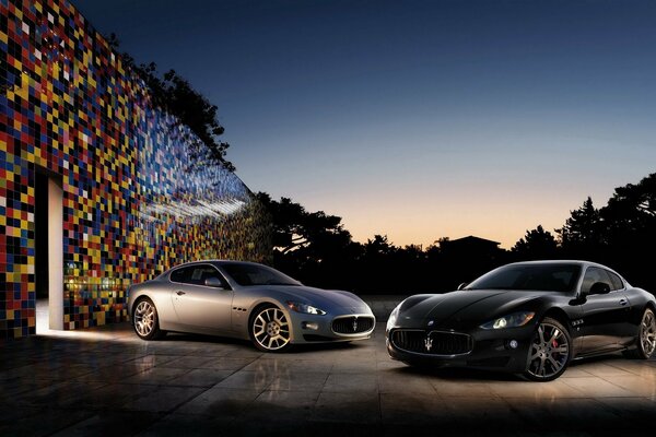 Two Maserati cars at the mosaic wall