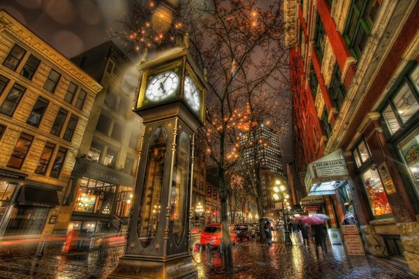 Reloj en la calle de la ciudad, gente con paraguas bajo la lluvia