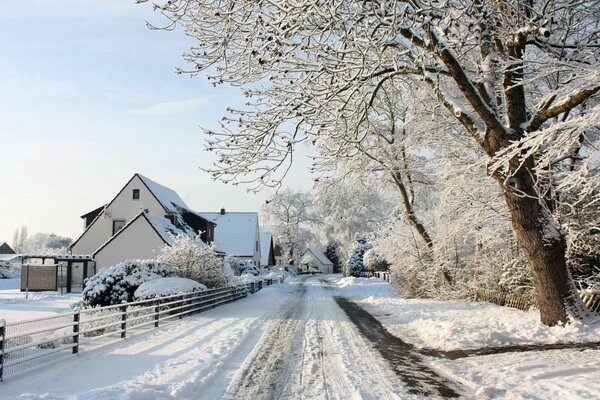 Strada invernale innevata nel villaggio