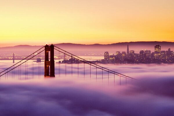 Golden Gate Bridge in San Francisco in foggy weather at sunset