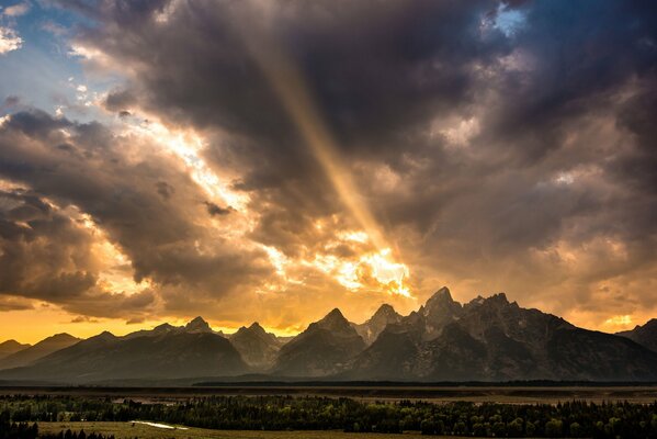 The sun sets behind the rocky Mountains