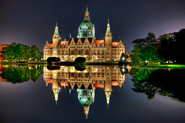 Evening castle on the shore of the lake and its reflection in the water.