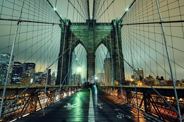 Le pont de Brooklyn de New York, filmé dans la nuit sur fond de gratte-ciel en feu