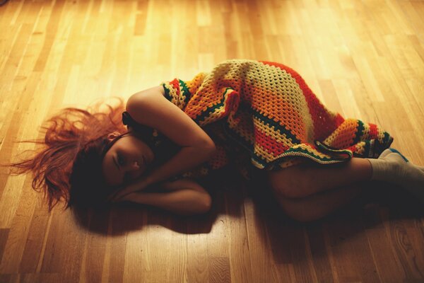 Ruda dziewczyna na podłodze w ciepłym świetle