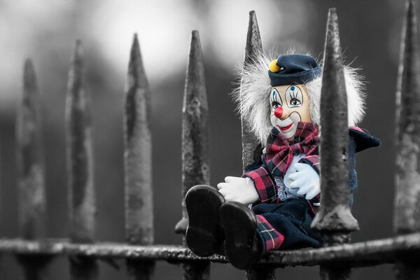 Toy clown on an iron fence