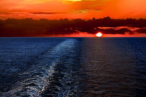 Roter Sonnenuntergang am Meer. Wolken über dem Wasser