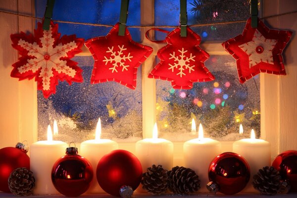 Decoraciones de Navidad. Velas y juguetes en una ventana cubierta de nieve