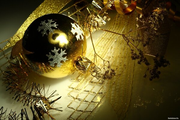 Boule de Noël dorée avec flocons de neige argentés