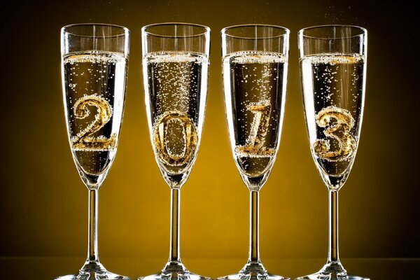 Vier Gläser Champagner mit Zahlen, die das kommende Jahr symbolisieren