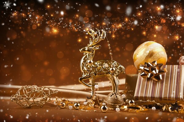 Новогодние украшения. Золотой олень рядом с новогодним подарком