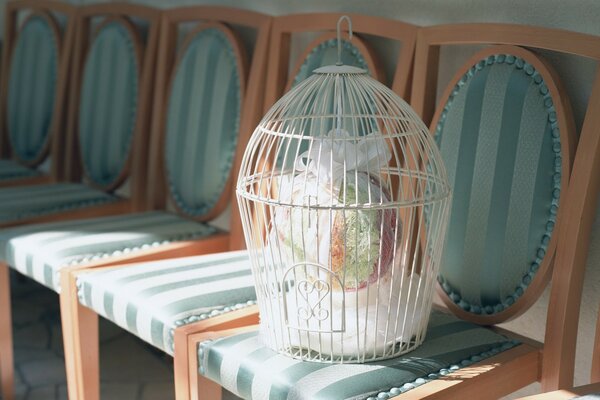 Bouquet de mariage en cage sur une chaise rayée