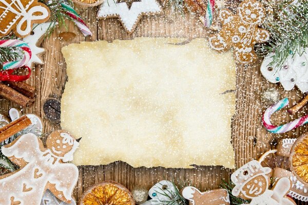 Christmas toys on a wooden table around a blank sheet for congratulations