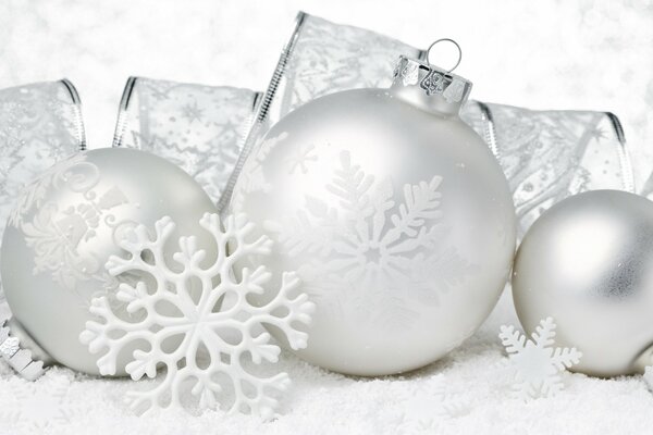 Silver balls lying on a wide ribbon and a large snowflake