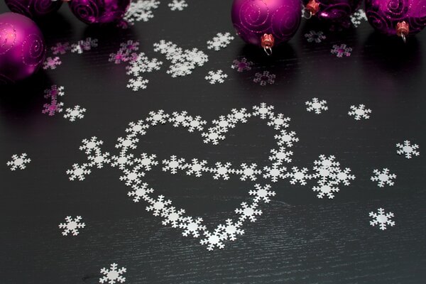 Snowflake pattern in the form of a heart with an arrow and Christmas tree toys