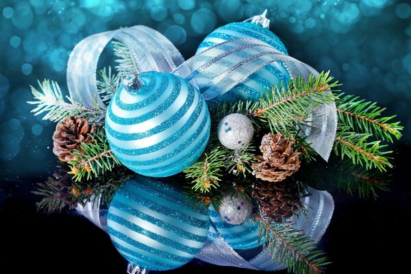 Ein Zweig eines Weihnachtsbaums, der mit einem Band und einem blauen Ball verziert ist