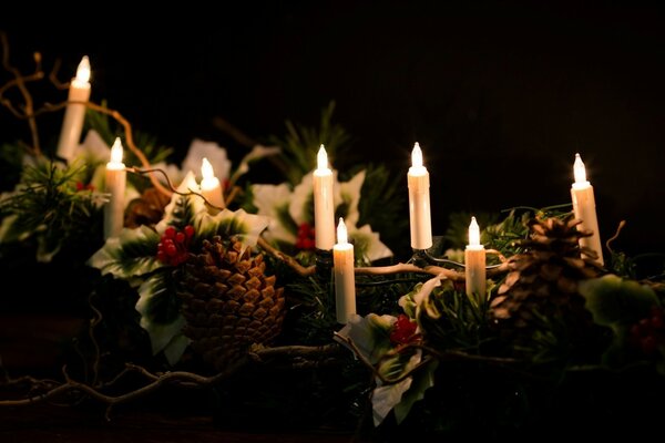 Velas de Navidad entre conos de Navidad