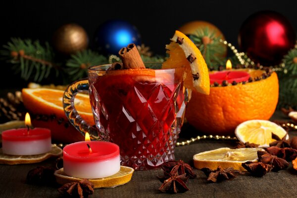 Becher mit Glühwein unter Kerzen