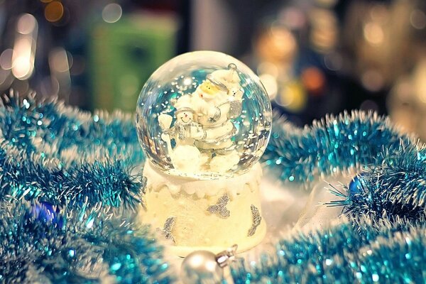 A Christmas tree ball lies among the tinsel