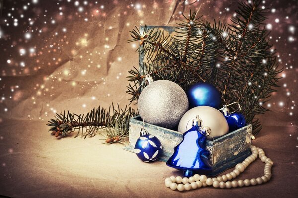 A box with Christmas balls and a string of pearl beads