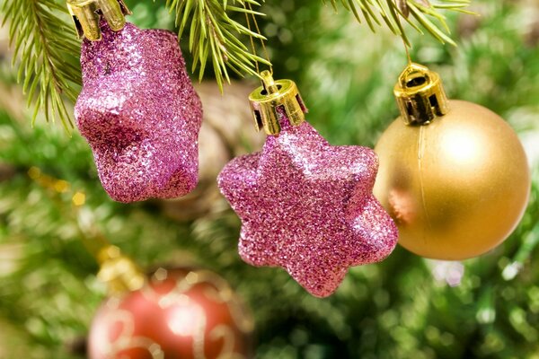 Estrellas Rosadas y bolas de pelo rojo en el árbol de Navidad