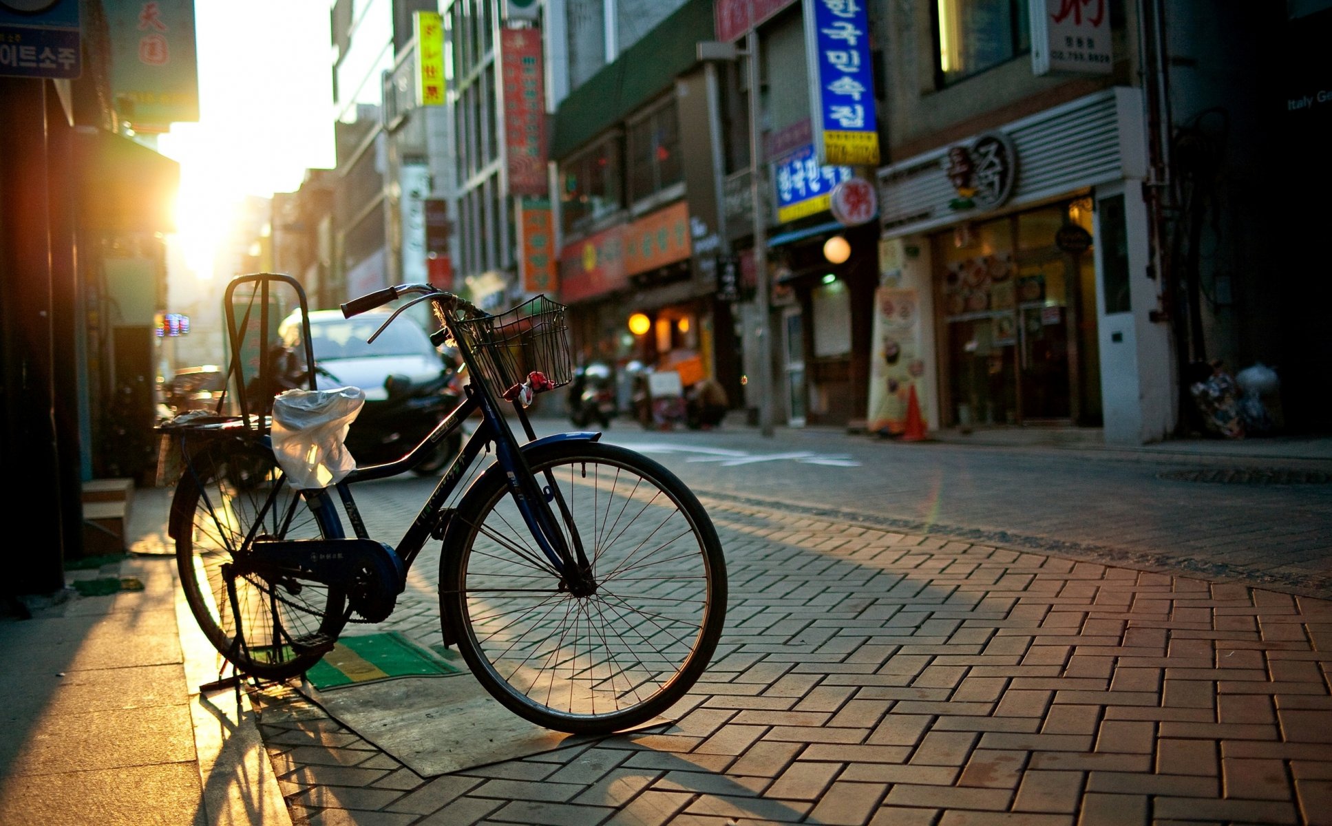 town street house shops signs windows road pavement bike morning sun ray