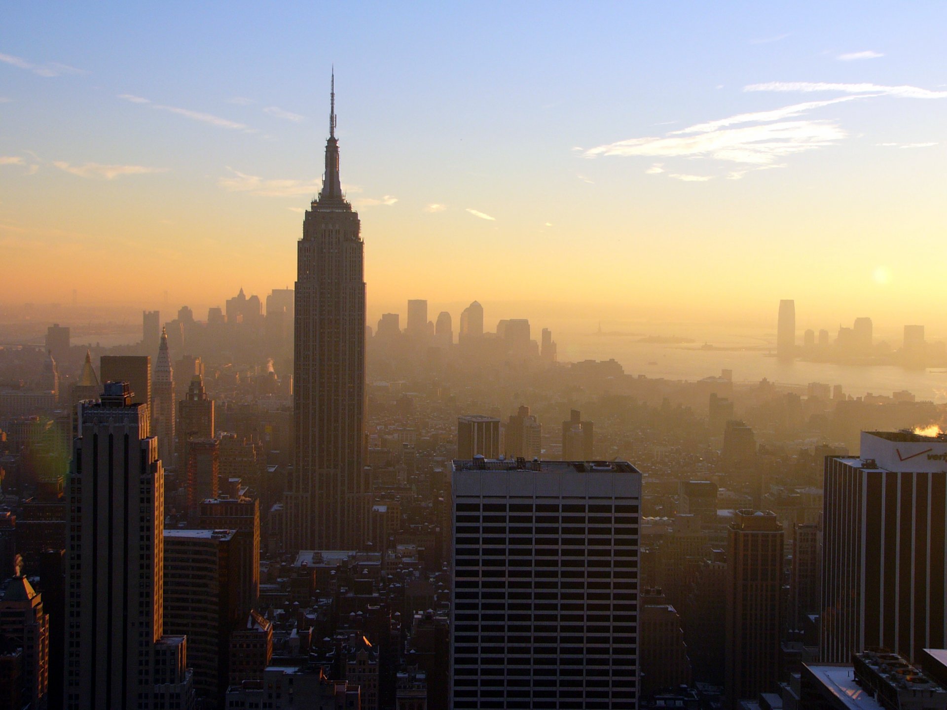 panorama estados unidos ciudad nueva york gran manzana manhattan centro de negocios empire state building empire state building casas edificios metrópolis tarde sol puesta de sol nubes cielo