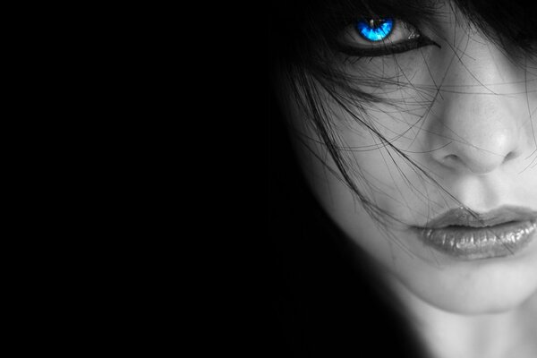 Weibliches Gesicht mit blauen Augen im Dunkeln