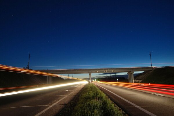 Evening sky over the highway illuminated by lights