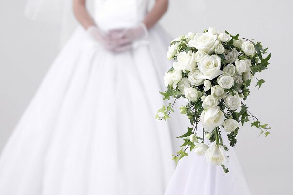 Brautstrauß und Kleid im Hintergrund