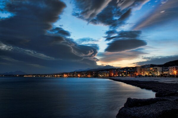 Imagen de la ciudad de la noche. Cielo al atardecer y playa desierta