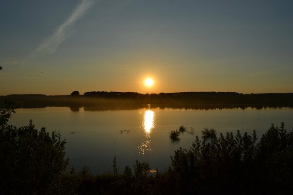 Hermosa puesta de sol en el lago en verano