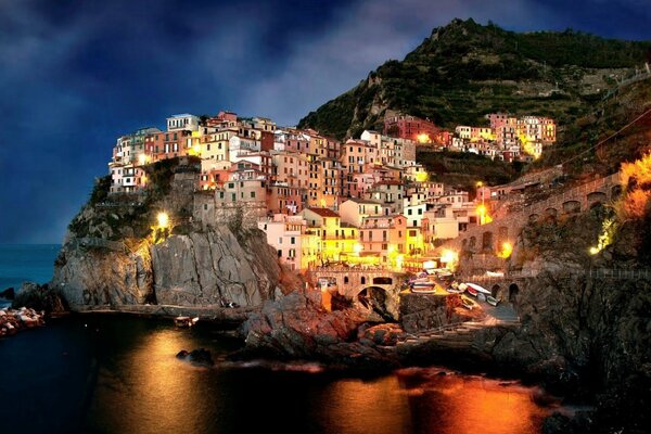 Nocne włoskie miasteczko na skałach nad morzem