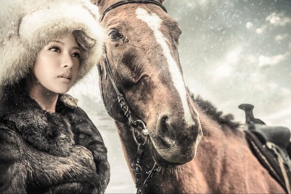 Hermosa chica en el fondo de la nieve y el caballo