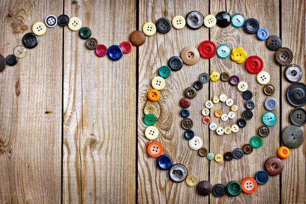 Spiral of buttons on a wooden table