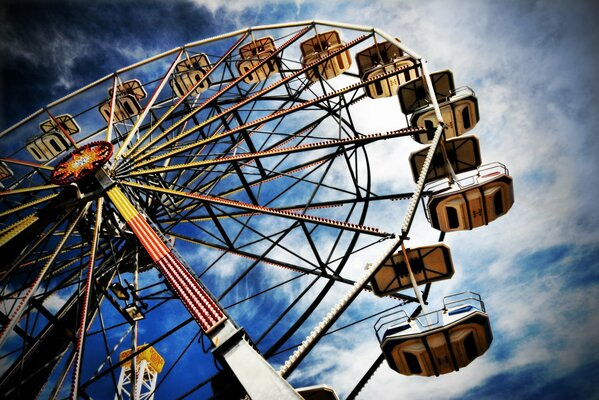 A Ferris wheel against a cloudy sky