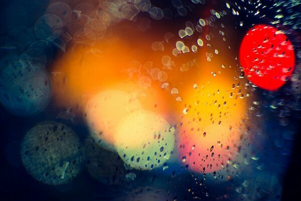 Salpicaduras de lluvia en el fondo de las luces de la ciudad