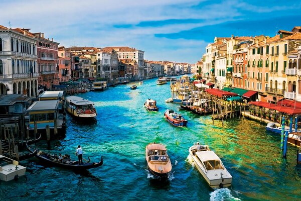 Barcos y barcos en el río Venecia. Hermosas casas y un paisaje brillante